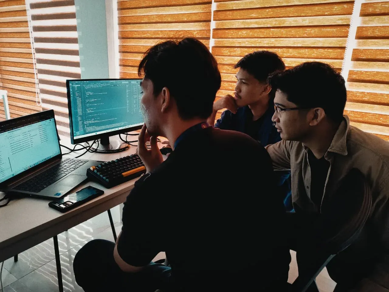 A2K developers reviewing code together at their desks